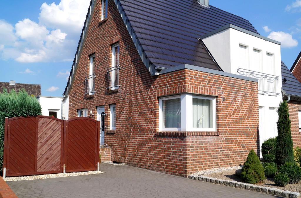 une maison en briques rouges avec un toit noir dans l'établissement Ferienwohnung Am Sundern, à Tecklembourg