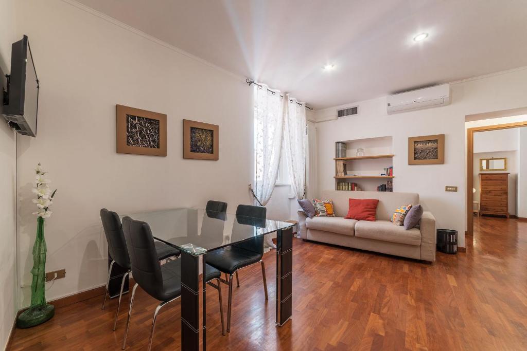a living room with a table and chairs and a couch at Casa Zeffiro - FromHometoRome in Rome