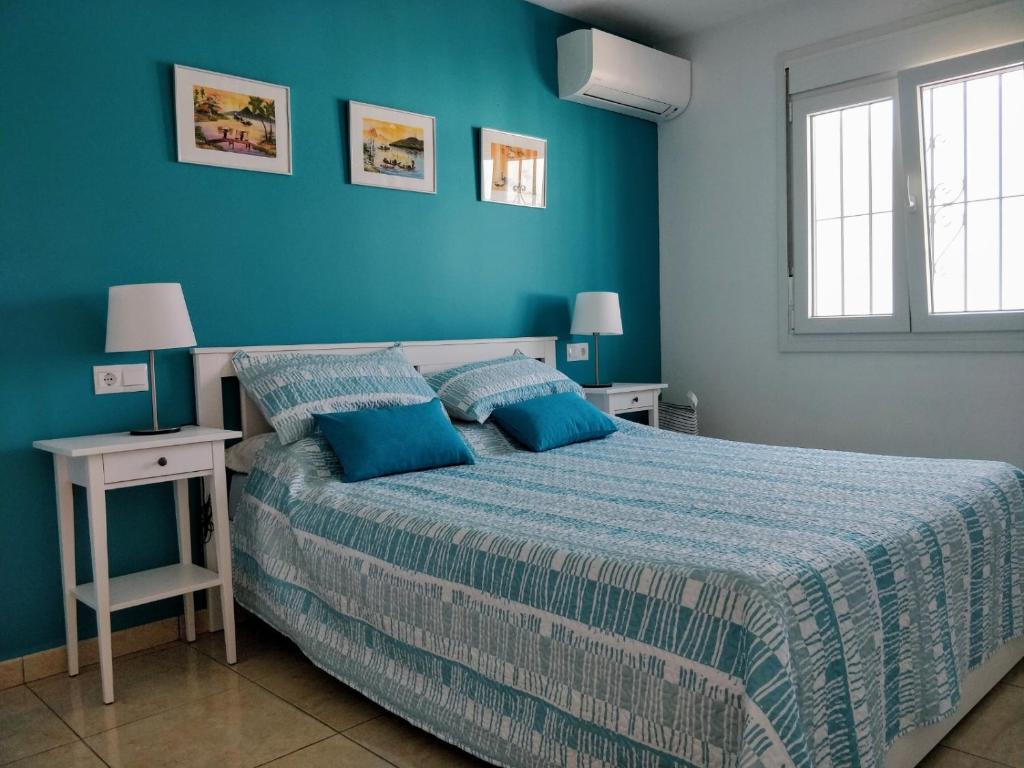 een slaapkamer met een bed en een blauwe muur bij Sunset view in Nerja