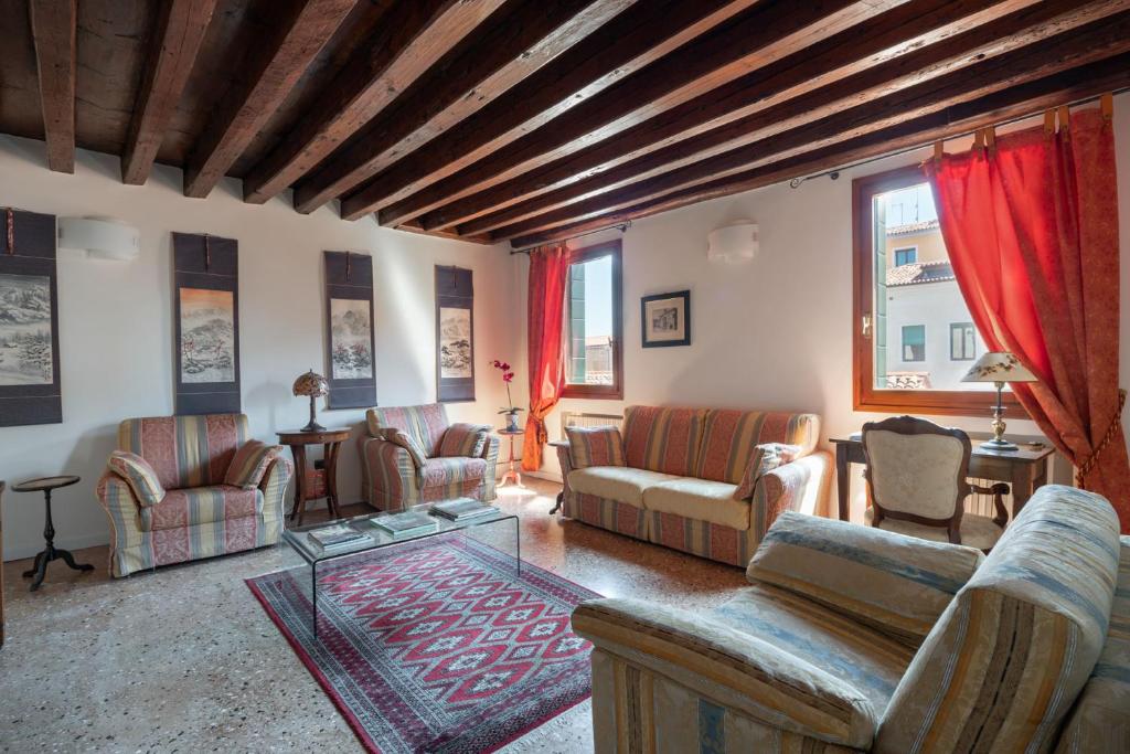 sala de estar con sofás, sillas y mesa en Ca' Coriandolo en Venecia