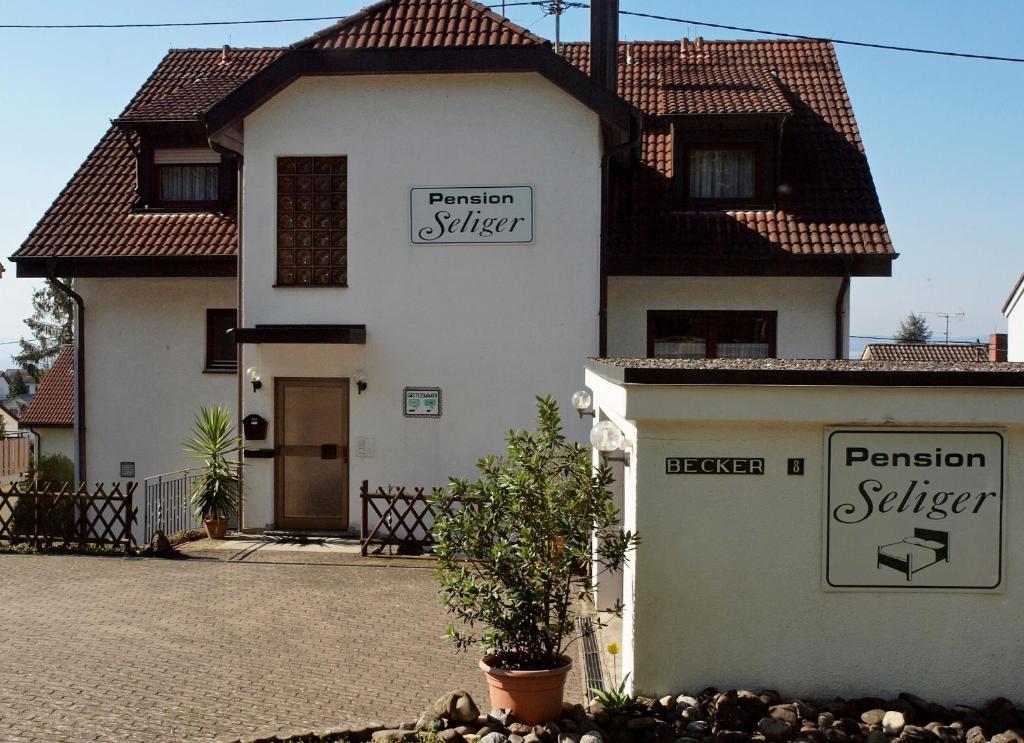 Una casa blanca con letreros a un lado. en Pension Seliger, en Meersburg