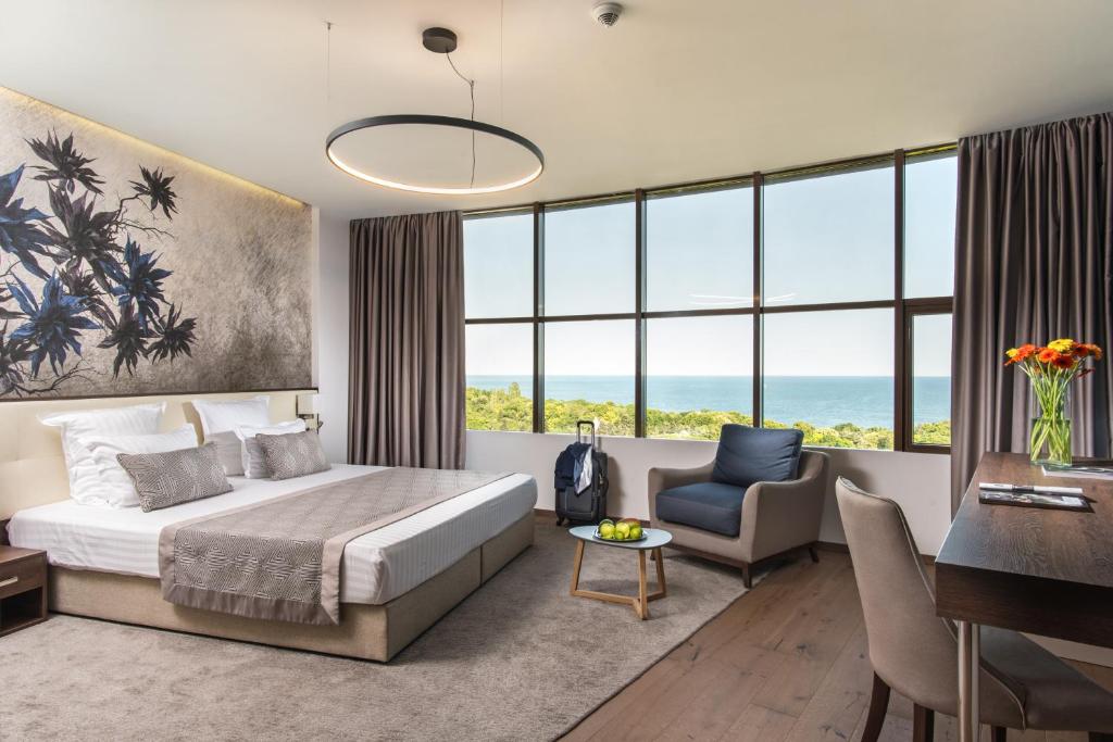 a bedroom with a bed and a desk and a chair at Rosslyn Dimyat Hotel Varna in Varna City