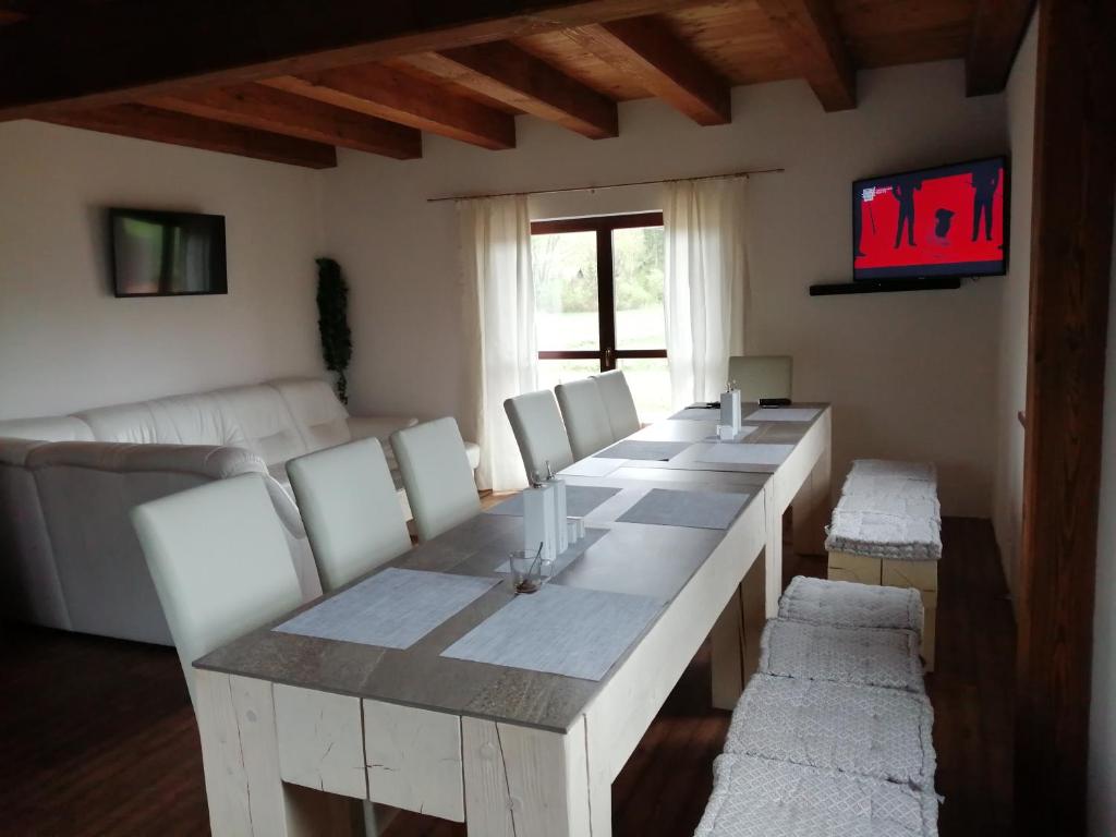 a living room with a long table and white chairs at Chalupy v Podkrkonoší- Chalupa Oto, Chalupa Prade in Hostinné