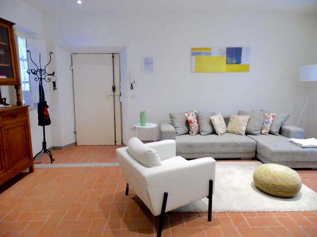 un soggiorno con divano e sedia di Casa dei Glicini a Lucca