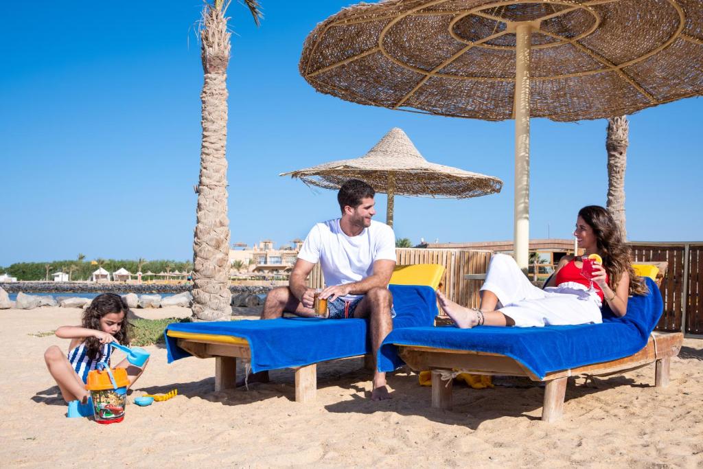 a group of people sitting on chairs on the beach at Desert Rose Resort in Hurghada