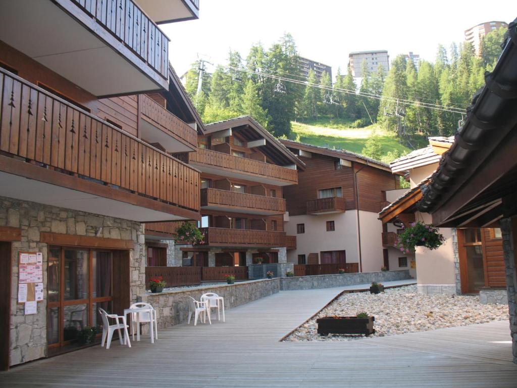 a courtyard of a building with chairs and tables at Lagrange Vacances Les Chalets Edelweiss in La Plagne