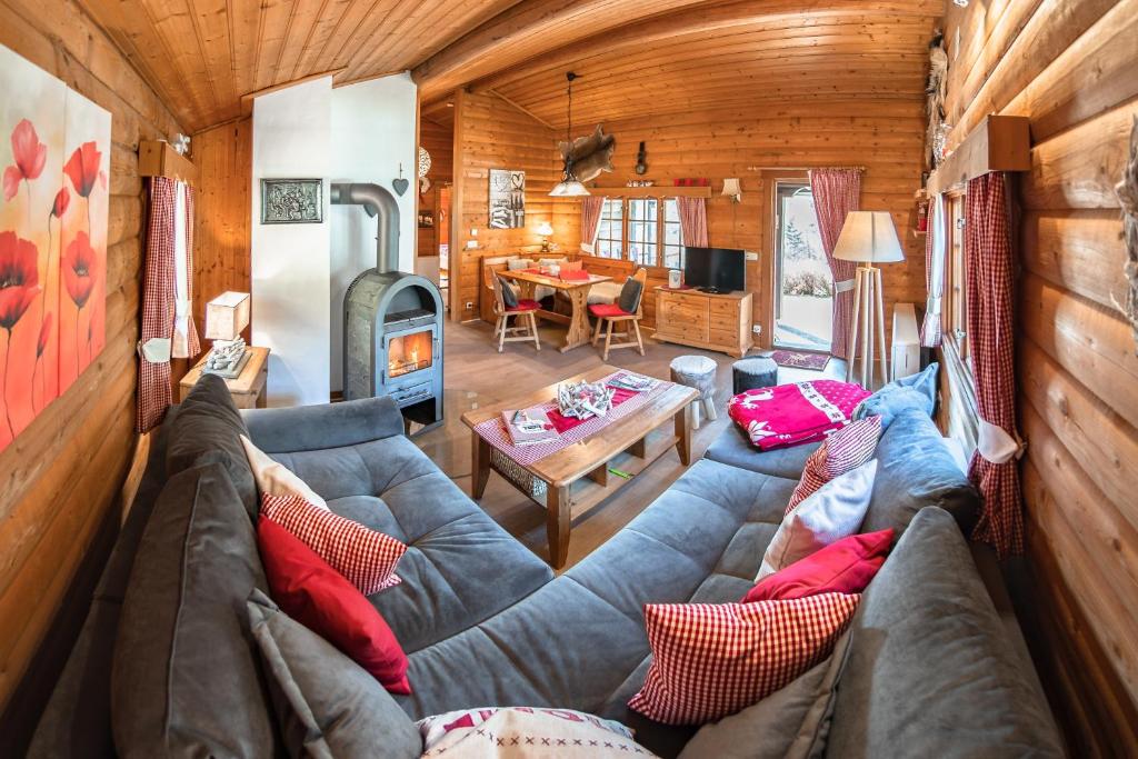 a living room with a couch and a fireplace in a log cabin at Bergchalet La Roubine Willingen in Neerdar