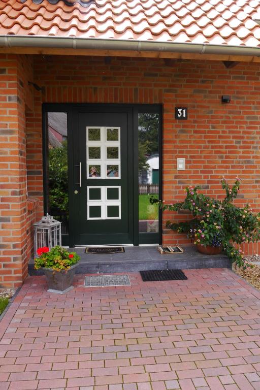 a green door on a brick house with flowers at Landhaus - Hof Pakirnis in Bleckede