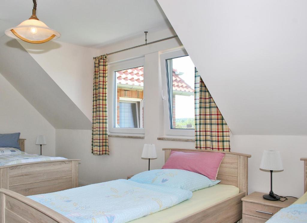 a bedroom with two beds and two windows at Landhaus - Hof Pakirnis in Bleckede