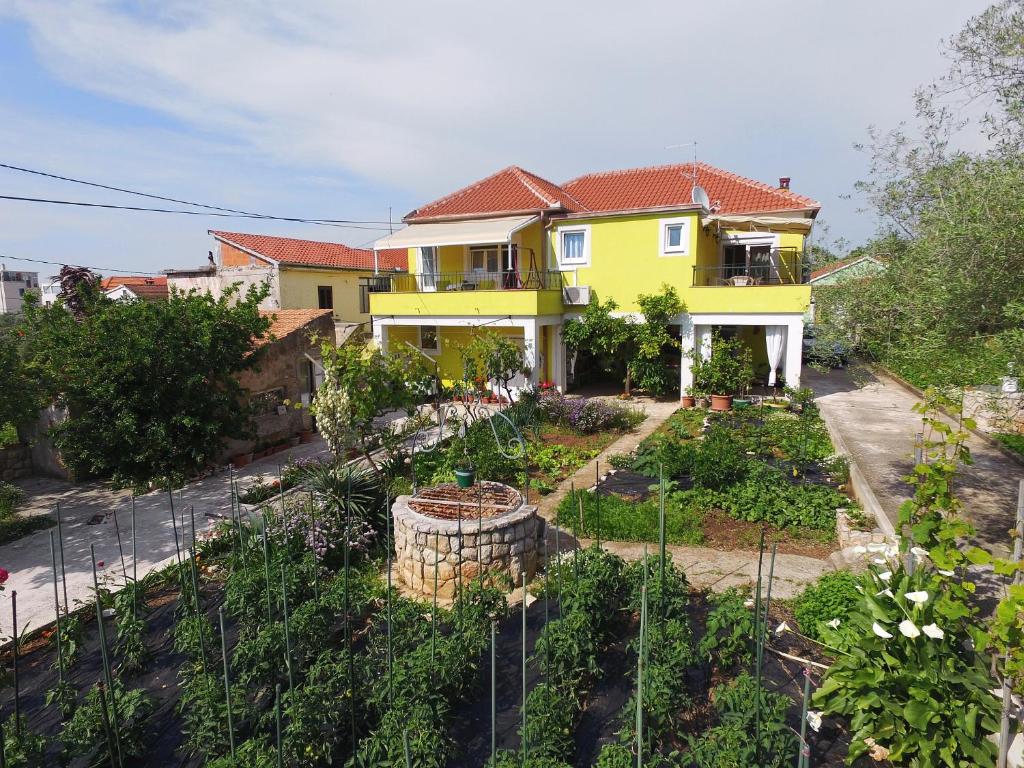 ein gelbes Haus mit Garten davor in der Unterkunft Senkini Dvori in Sutomišćica