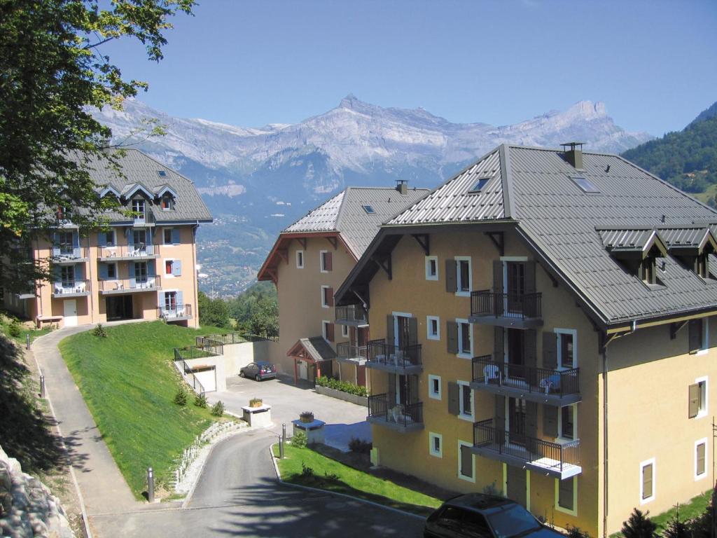 un grupo de edificios con montañas en el fondo en Lagrange Vacances Les Arolles en Saint-Gervais-les-Bains