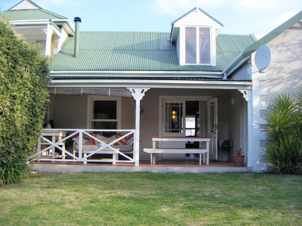 a house with a porch with a bench on it at 4214 Riverclub in Plettenberg Bay
