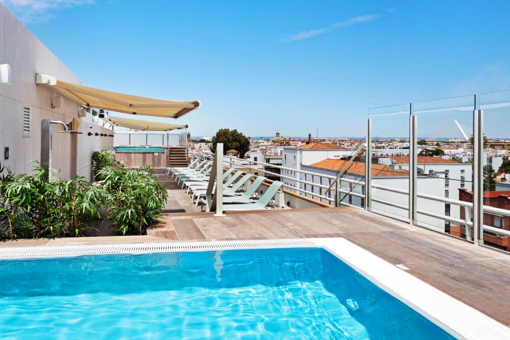 
a balcony overlooking a beach with a swimming pool at Catalonia Santa Justa in Seville
