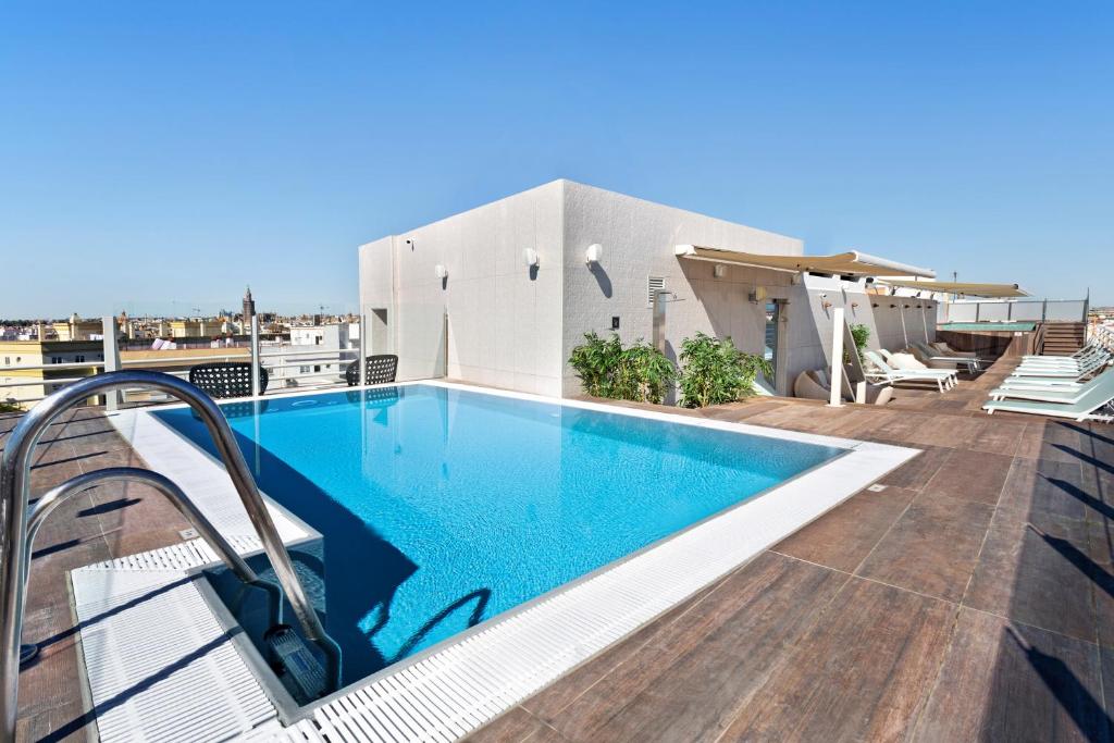 a swimming pool on the roof of a house at Catalonia Santa Justa in Seville