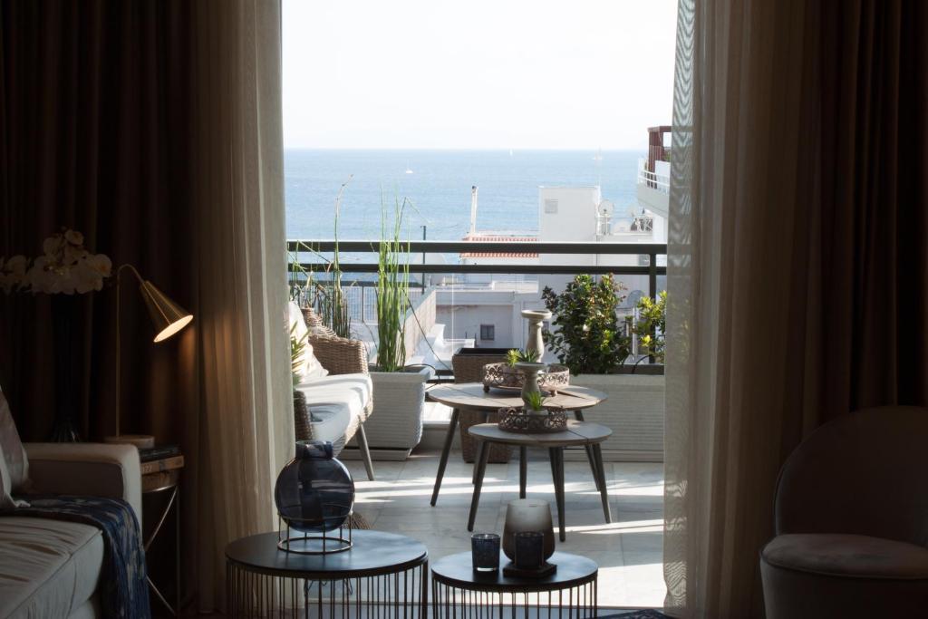 a living room with a view of the ocean from a balcony at Sea view super romantic apartment in Athens