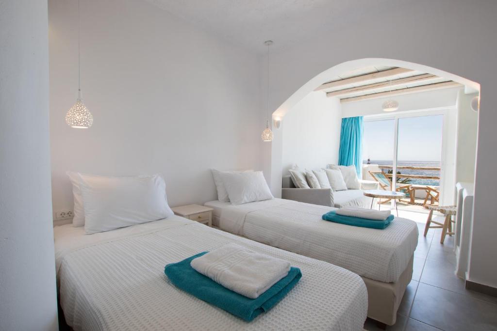 two beds in a room with a view of the ocean at Poseidon Blue Gastronomy Hotel in Afiartis