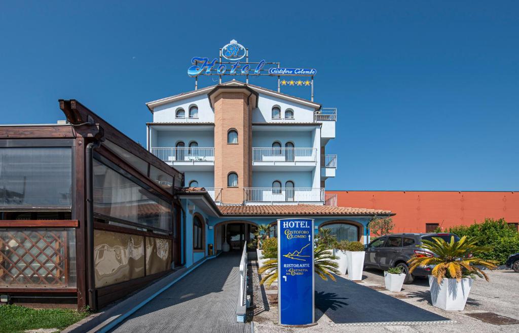 un edificio con un cartello di fronte di Hotel Cristoforo Colombo a Osimo