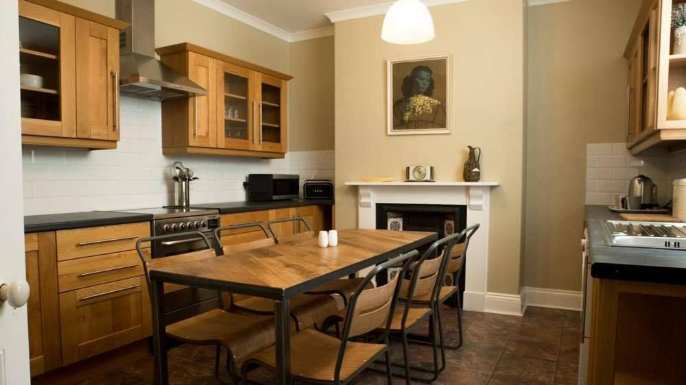 eine Küche mit einem Tisch und Stühlen sowie einem Kamin in der Unterkunft Kittiwake Number 4 - Town Centre & Spacious in Bridlington