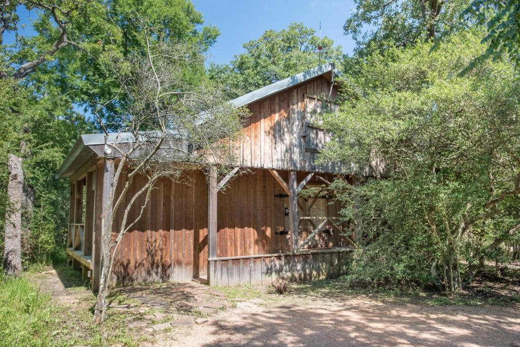 an old barn in the woods with trees at 7F Lodge and Events in College Station
