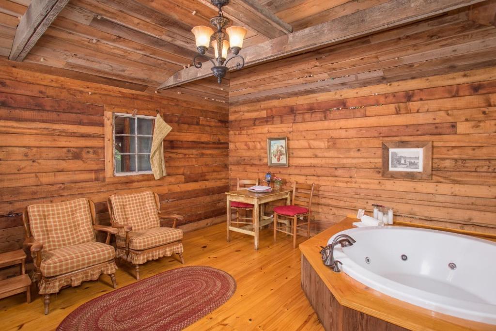 a bathroom with a tub and a table and chairs at 7F Lodge and Events in College Station