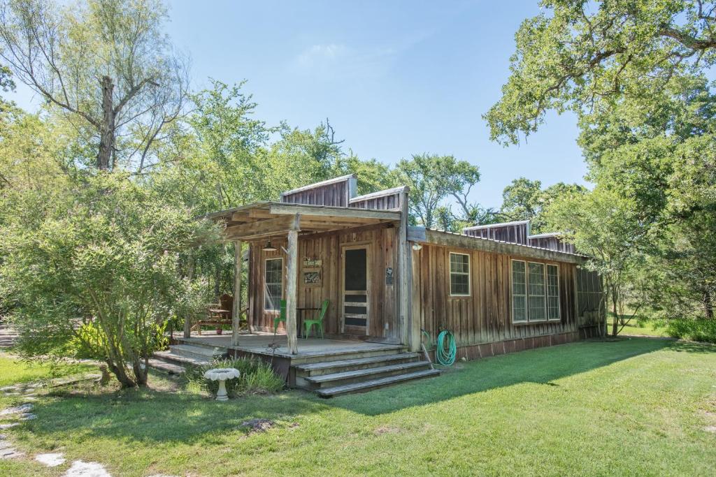 a tiny house with a porch in a yard at 7F Lodge and Events in College Station