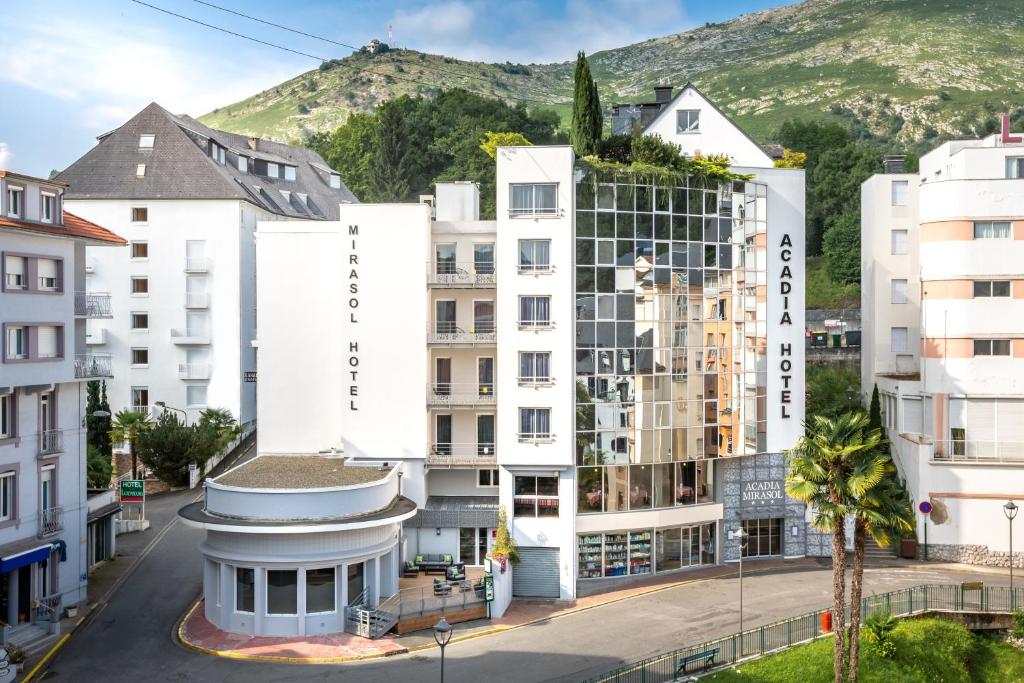 a city with buildings and a mountain in the background at Hôtel Acadia in Lourdes