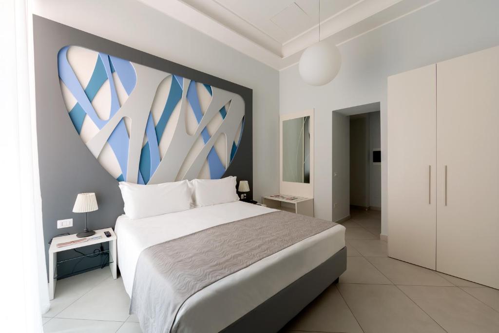 sypialnia z dużym łóżkiem z niebiesko-białym zagłówkiem w obiekcie Dioniso’s Luxury Apartments Municipio w mieście Napoli