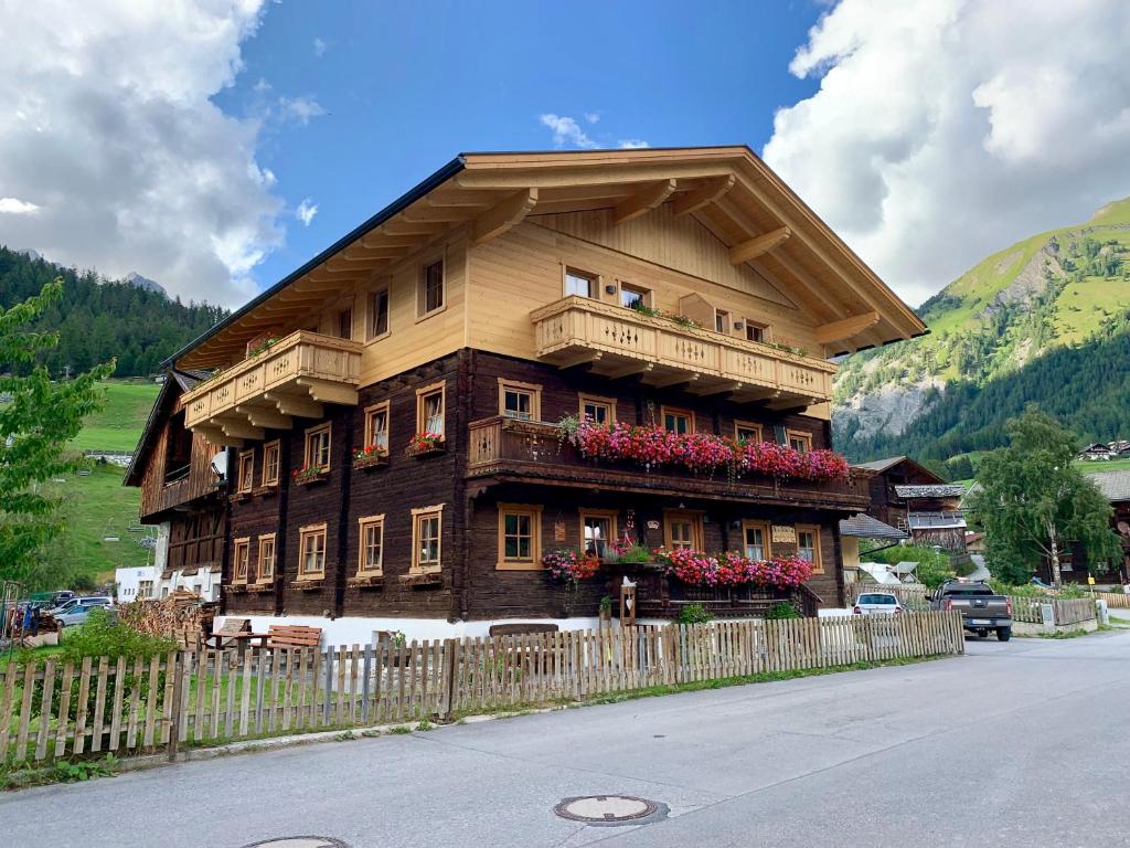 a wooden house with a balcony and a fence at Kererhof in Kals am Großglockner