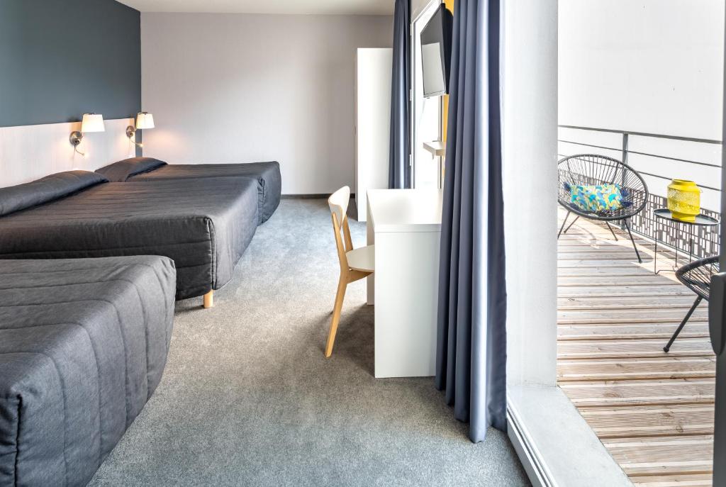 1 dormitorio con 1 cama, 1 mesa y 1 silla en Hôtel Mirasol en Lourdes