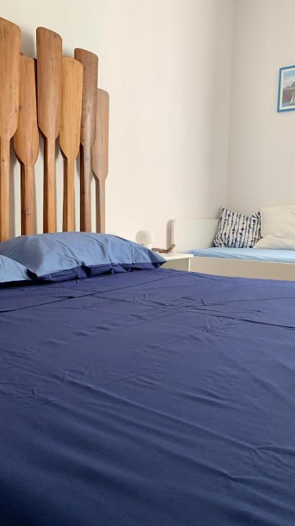 una camera da letto con un letto con lenzuola blu e sedie di legno di SUD 47 a Molfetta