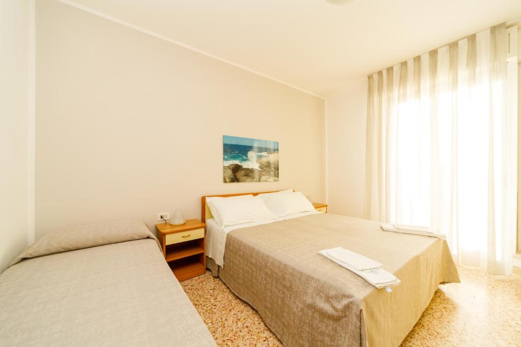 A bed or beds in a room at Albergo Roma Spiaggia