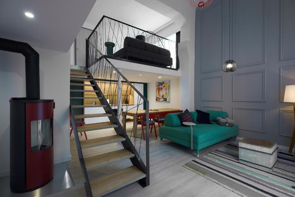 a living room with a staircase and a green couch at 7Domb Apartman in Komló