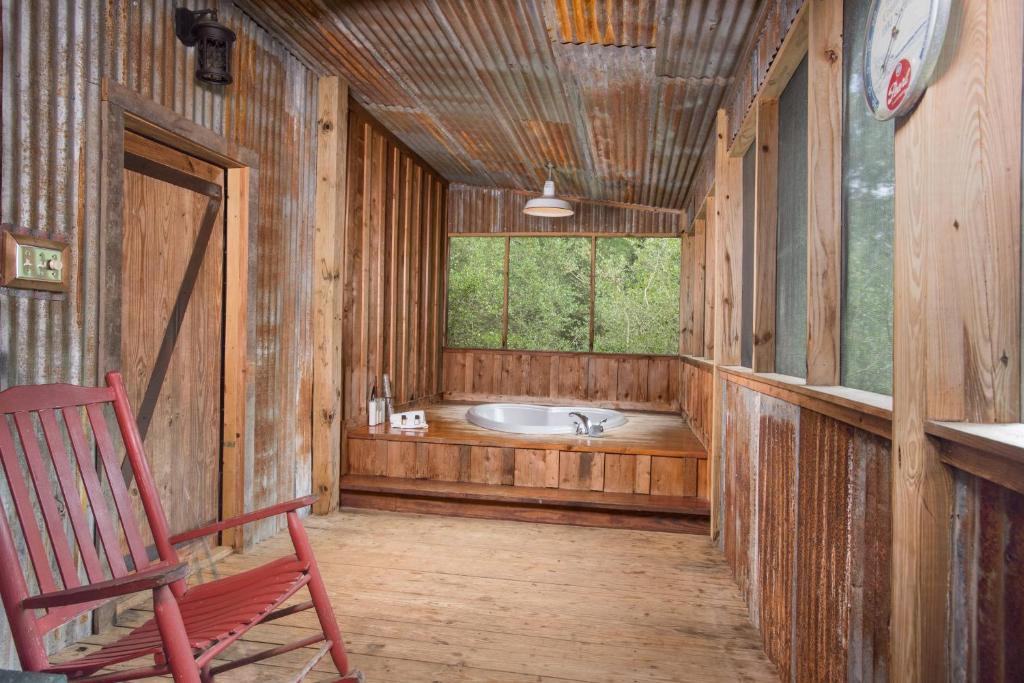 a bathroom with a tub and a chair and a window at 7F Lodge and Events in College Station