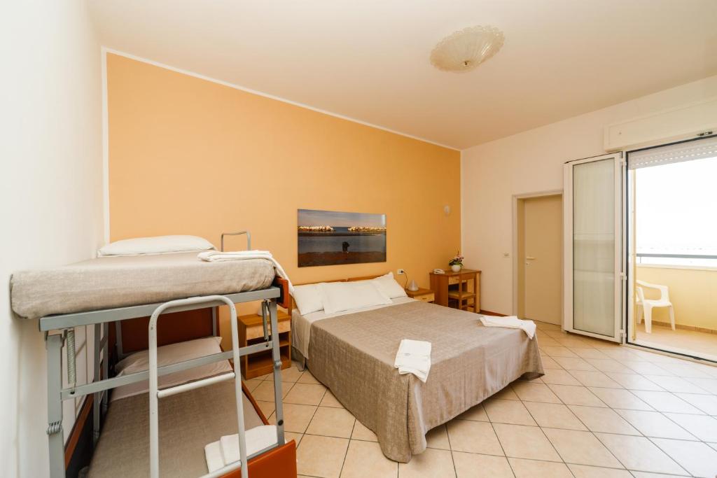 A bed or beds in a room at Albergo Roma Spiaggia