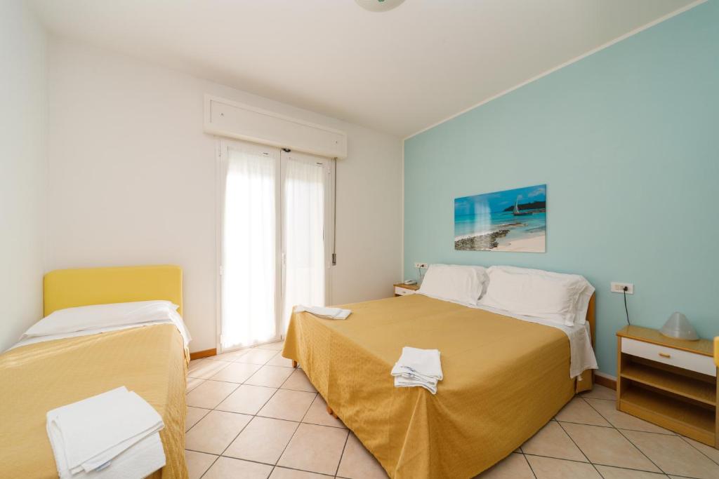 A bed or beds in a room at Albergo Roma Spiaggia
