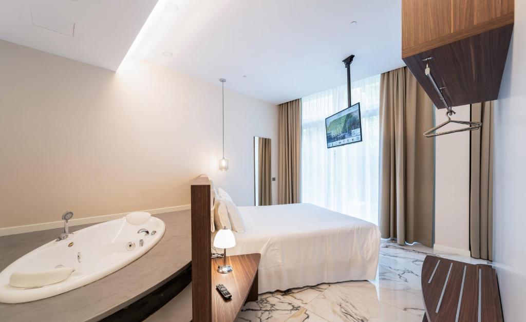 a hotel room with a bath tub and a bed at Hotel Milano Castello in Milan