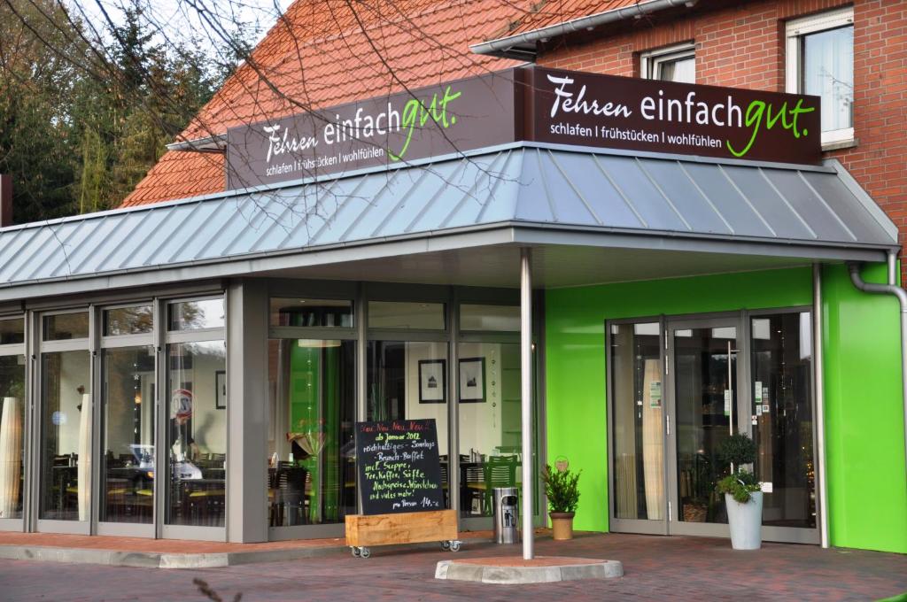 ein Geschäft vor einem Restaurant mit grüner Fassade in der Unterkunft Fehren einfach gut in Lingen