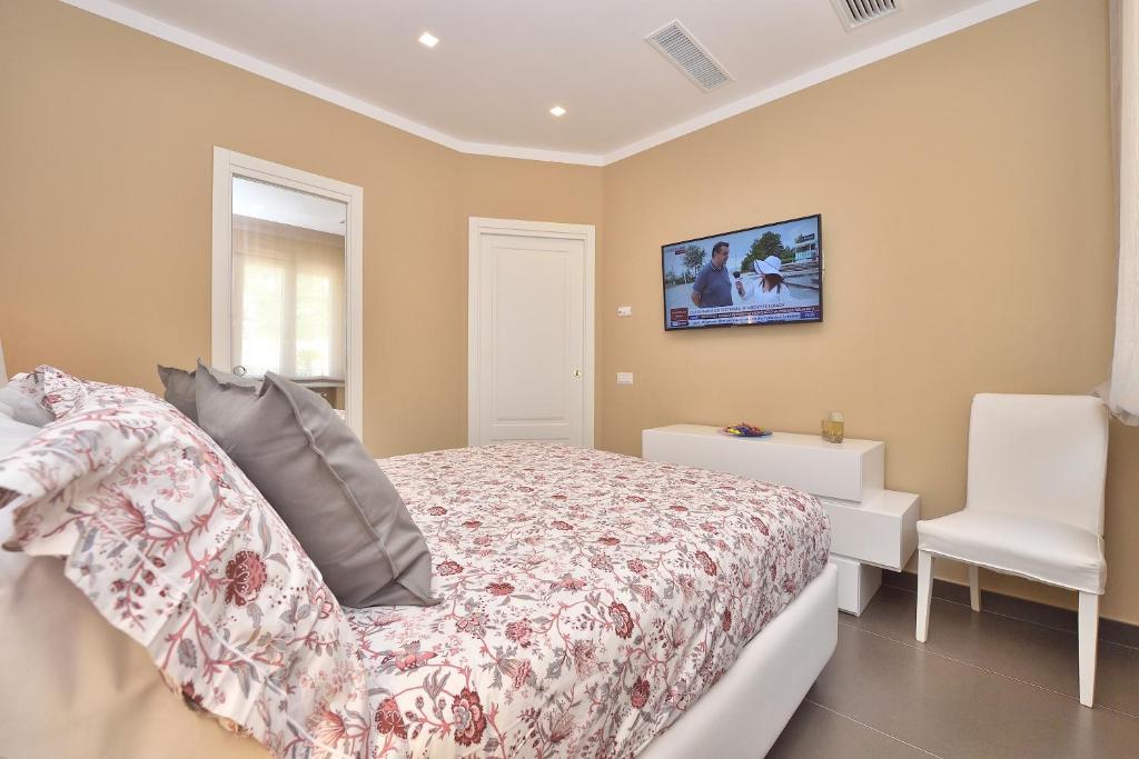 sypialnia z łóżkiem i białym krzesłem w obiekcie Costa d'Amalfi Apartments w mieście Minori