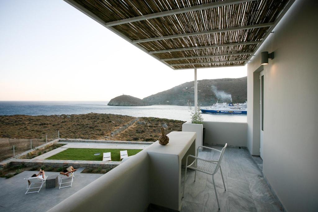 a house with a balcony with a view of the ocean at Pharos Apartments in Gavrio