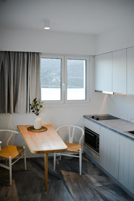 a kitchen with a table and a table and chairs at Pharos Apartments in Gavrio