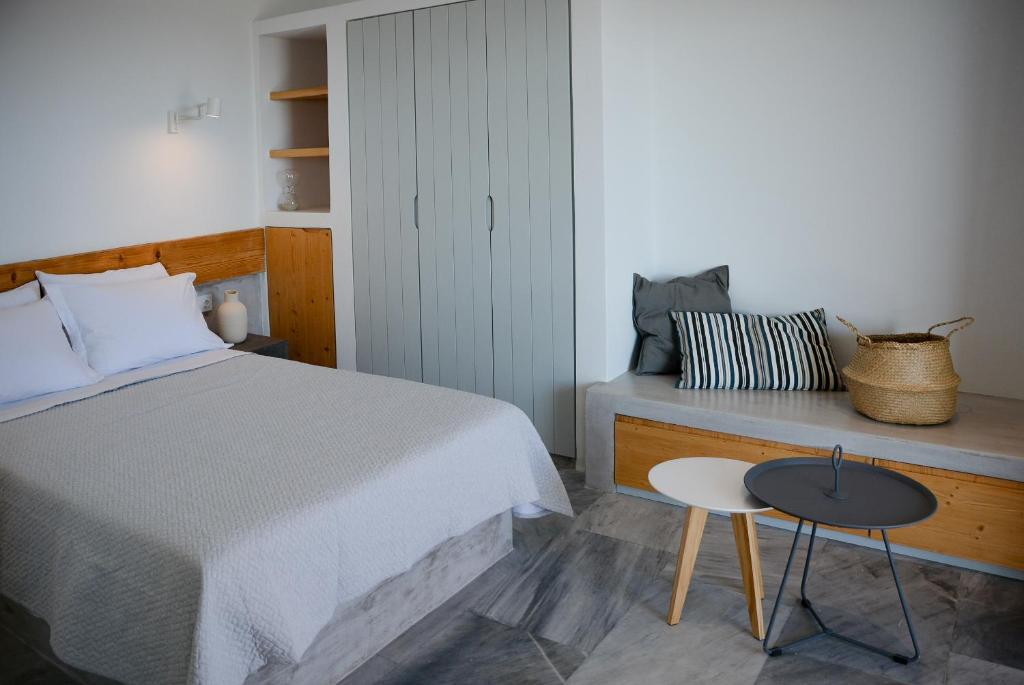 a bedroom with a bed and a table and a chair at Pharos Apartments in Gavrio