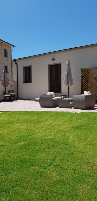 un patio con 2 sofás y una sombrilla en un patio en ALBELDI', en Domus de Maria