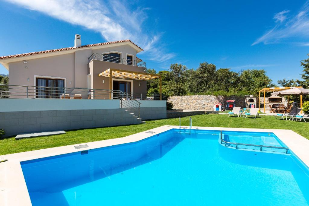 una villa con piscina di fronte a una casa di Anatoli Villa, Tranquil Retreat, By ThinkVilla a Orthés