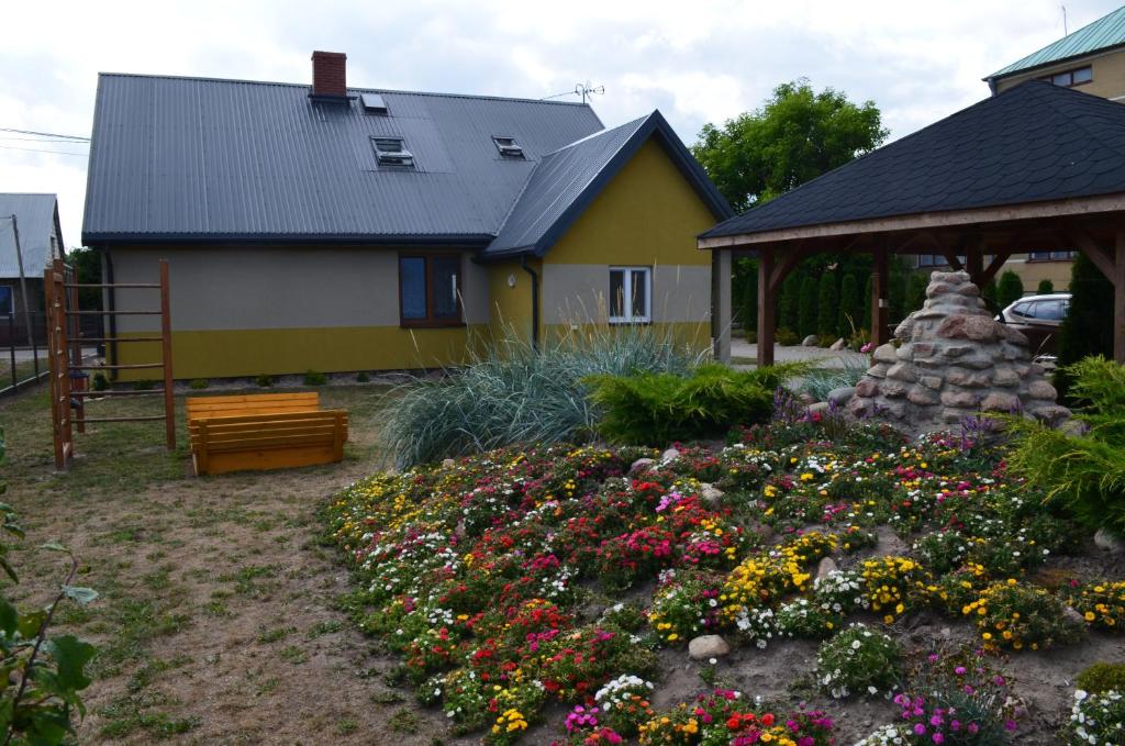 una casa con un jardín con flores en el patio en Chata Rybaka, en Suchowola