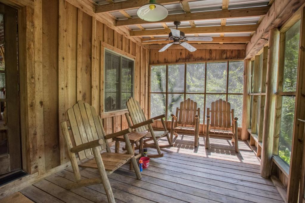 a porch with three chairs and a ceiling fan at 7F Lodge and Events in College Station
