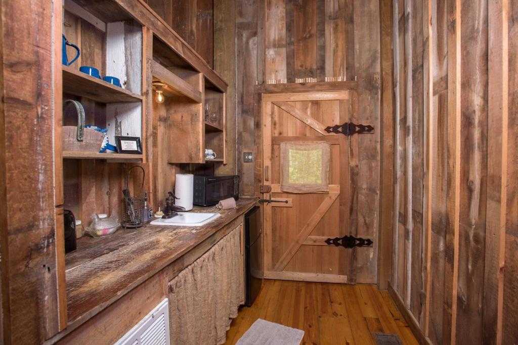 a kitchen with a counter with a sink and a door at 7F Lodge and Events in College Station