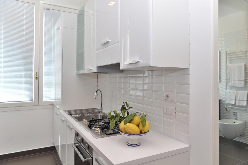 biała kuchnia z miską owoców na ladzie w obiekcie Costa d'Amalfi Apartments w mieście Minori