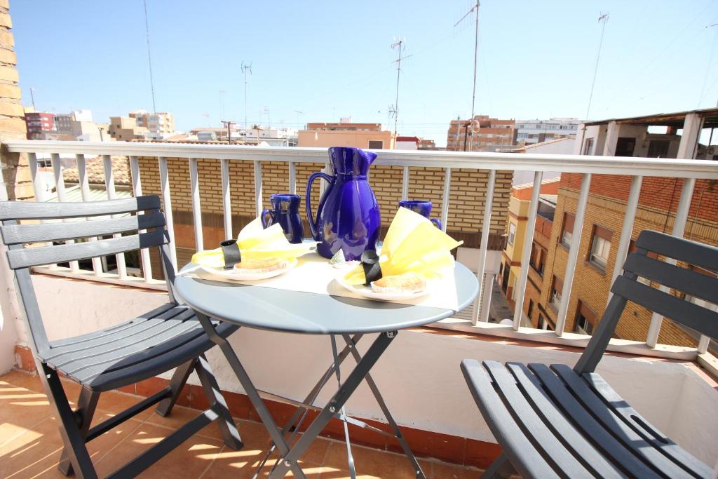 a table and two chairs on a balcony at Un impresionante apartamento cerca de la playa/An impressive apartment near the beach. in Puerto de Sagunto