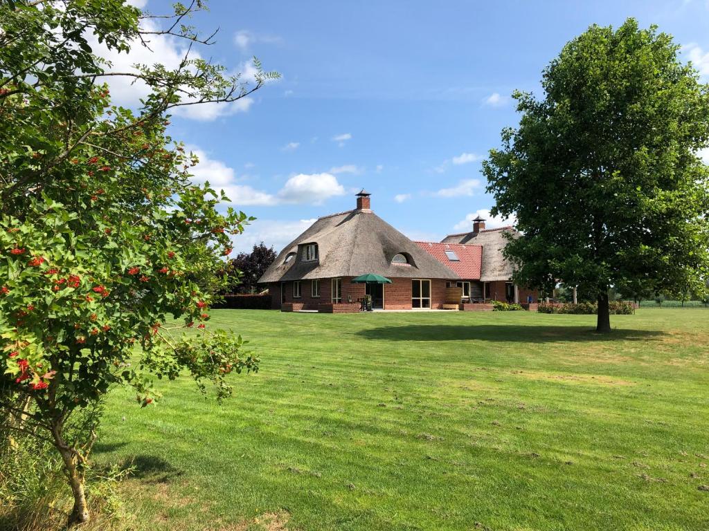 une vieille maison avec un arbre en face dans l'établissement Landgoed De Blaauwe Blaer, à Hall