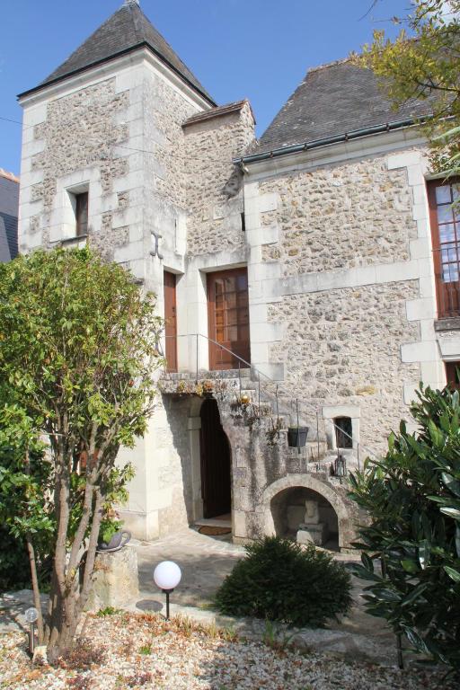 un antiguo edificio de piedra con un balcón en el lateral en Gîte Au près du Lys en Saint-Martin-le-Beau